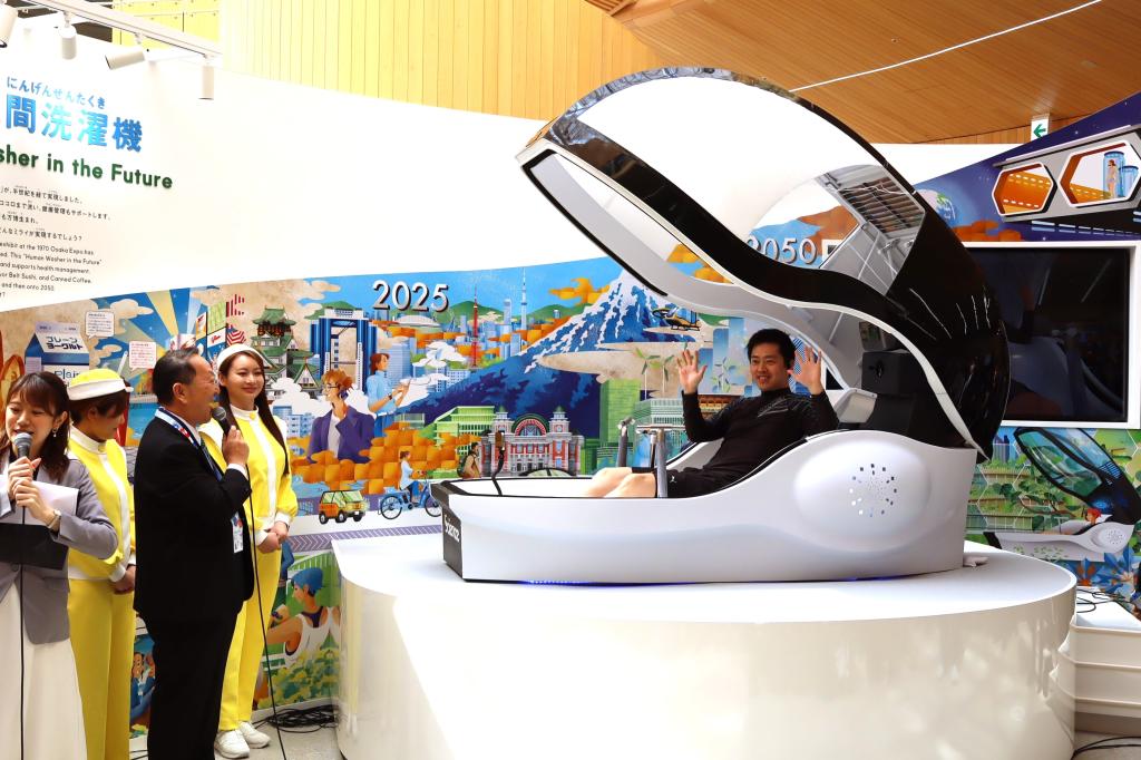 大阪ヘルスケアパビリオンで「ミライの人間洗濯機」を体験する大阪府の吉村洋文知事（２５年３月）
