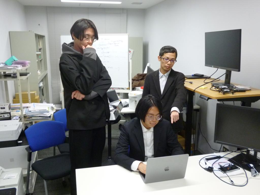 研究室で学生の指導にあたる野中准教授（後方右）