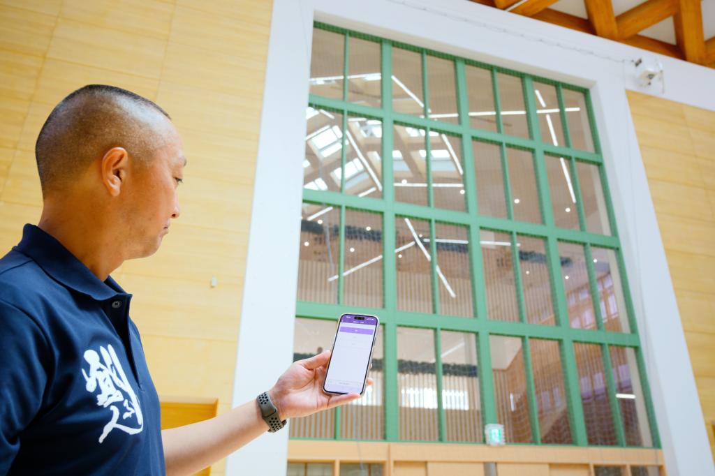 <strong>教員がスマートフォンを使い遠隔で設備の稼働を操作する</strong>（内田洋行）