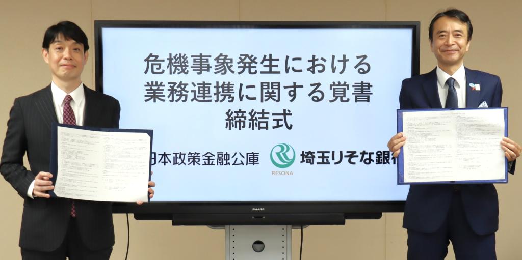 覚書を手にする埼玉りそな銀行の福岡聡社長（右）