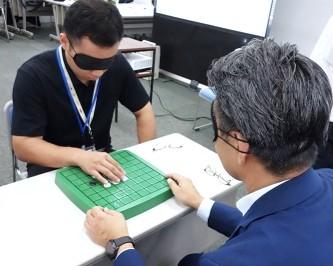 石と盤が一体化したオセロを体験する参加者