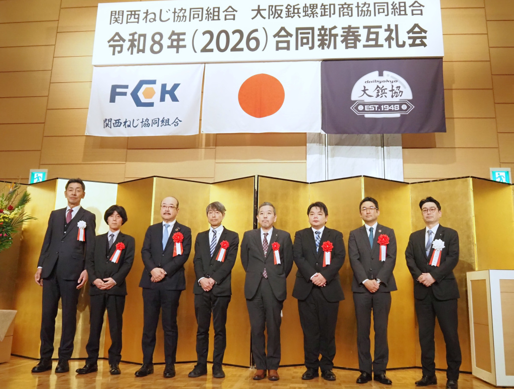 大鋲協と関西ねじ協組の合同新春互礼会のあいさつで壇上に並ぶ 大山寛之大鋲協理事長（左端）と西川倫史関西ねじ協組理事長（右端）