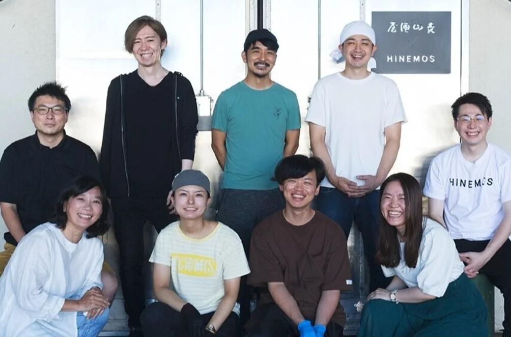 ＲｉｃｅＷｉｎｅの酒蔵（冷蔵倉庫内）の前で社員たちと（後列中央が酒井社長）