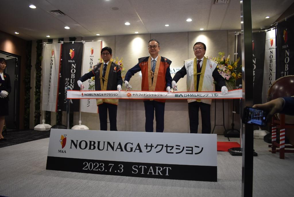 左からテープカットする福井基泰社長、池田直樹十六フィナンシャルグループ社長、三宅卓日本Ｍ＆Ａセンターホールディングス社長