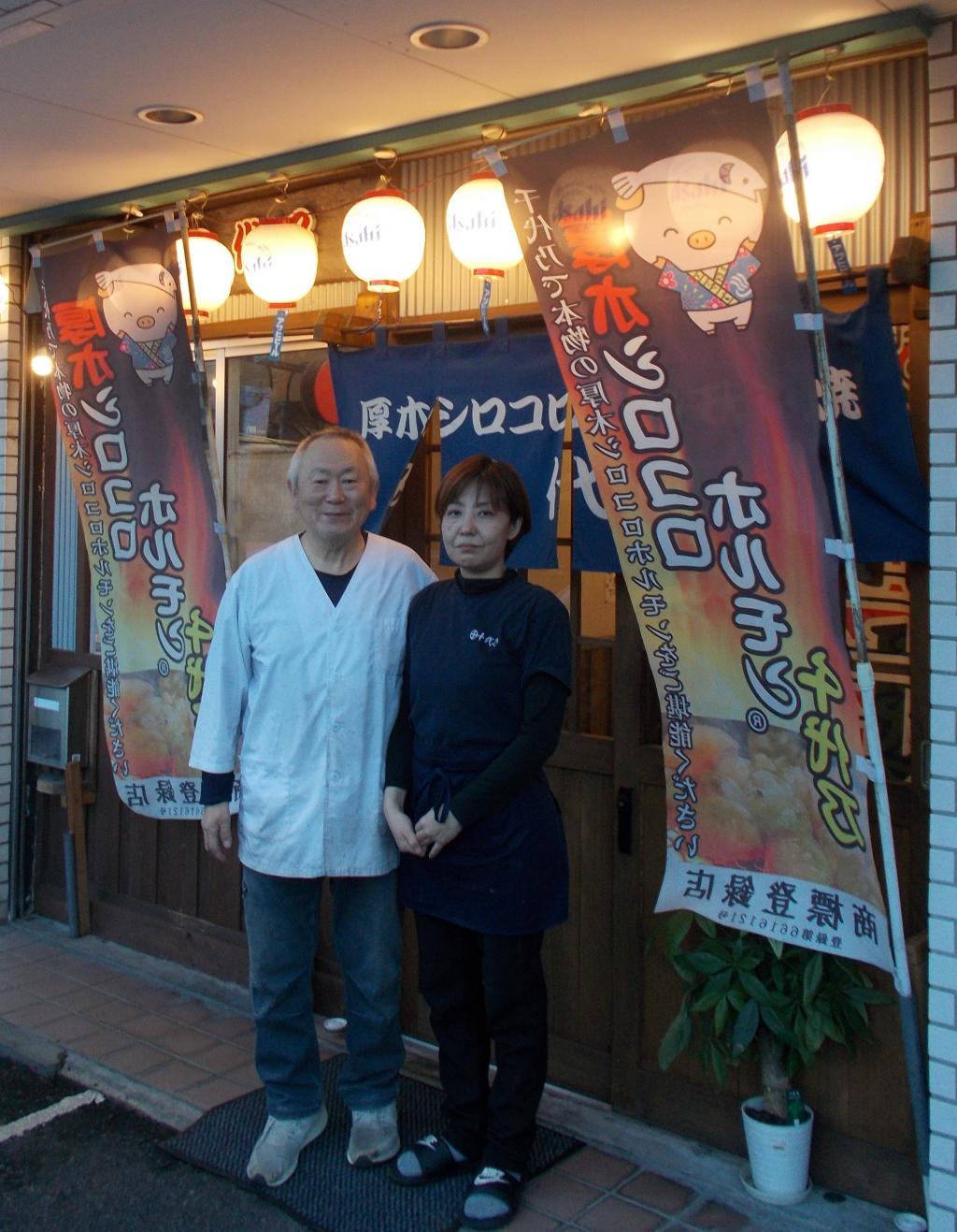 「厚木シロコロホルモン焼き千代乃」として、のれんを引き継いだ新店舗の前で（店主の内山さん(右)と島津さん）